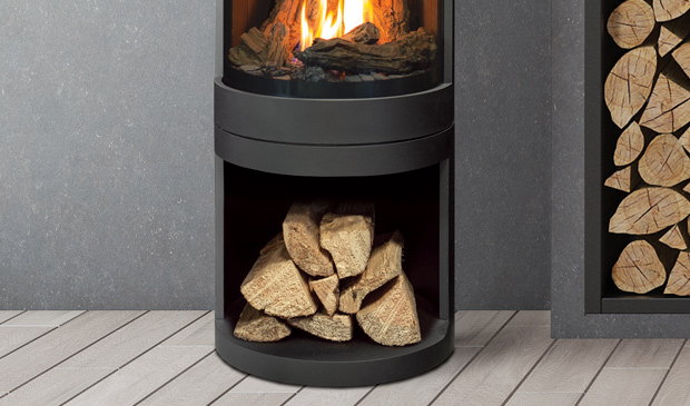 Black Enviro S50 with its wood storage base beside a log wall