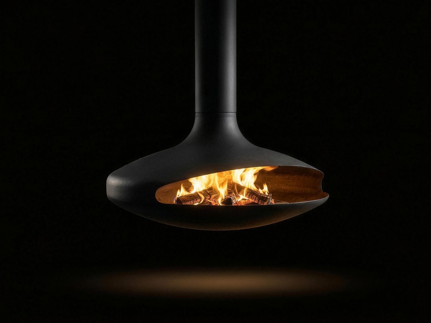 The Gyrofocus suspended wood fireplace burning with an open fire, photographed on black