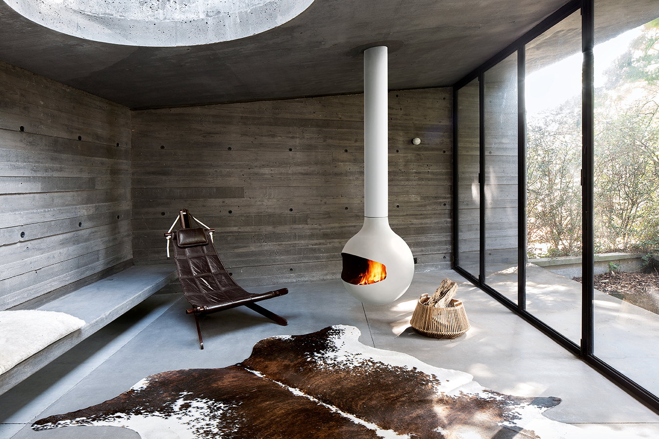White Bathyscafocus suspended in a board-formed concrete room over a cowhide rug