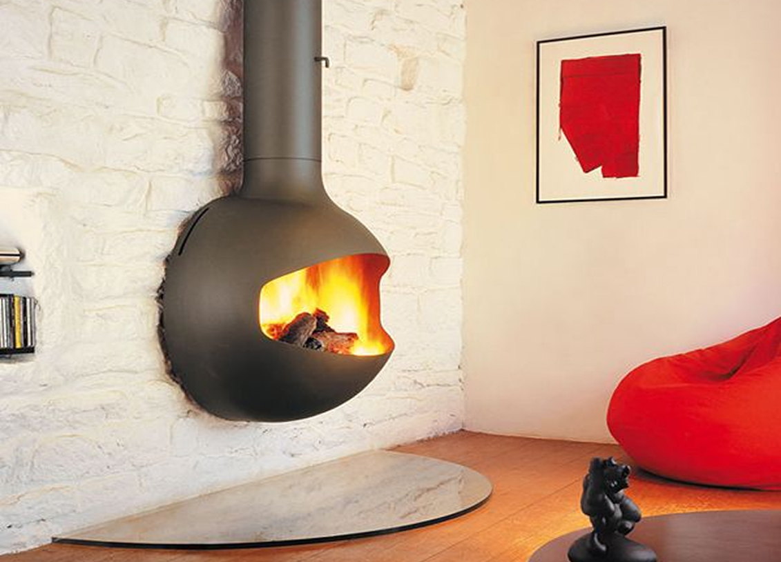 Black Emifocus wall fireplace burning on a white stone wall above a red beanbag
