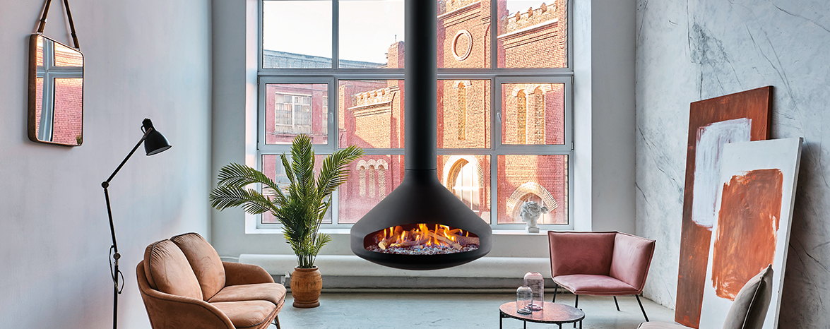 Ergofocus Gas suspended in a tall loft window bay between two pink armchairs, gas flame lit