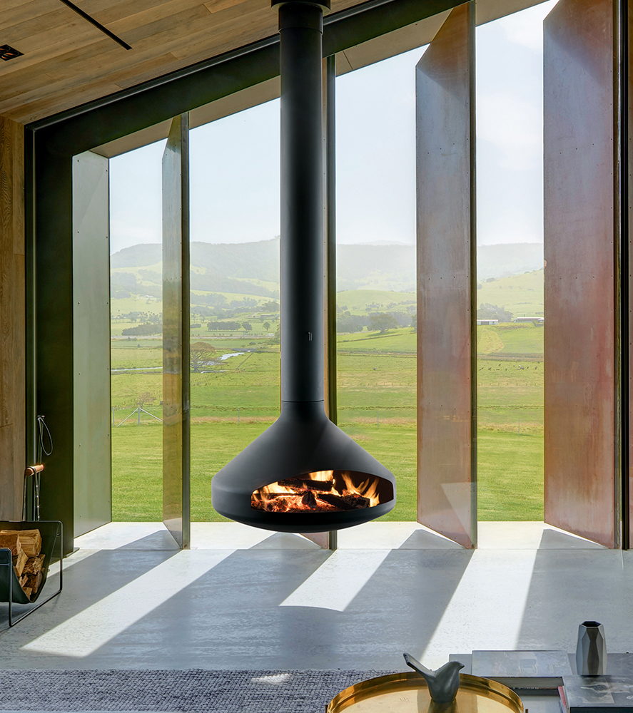 Black Ergofocus suspended before pivoting corten glass doors over a green valley