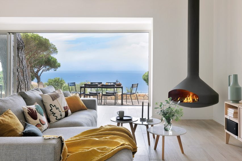 Black Ergofocus burning in a seaside living room with a yellow throw on the sofa