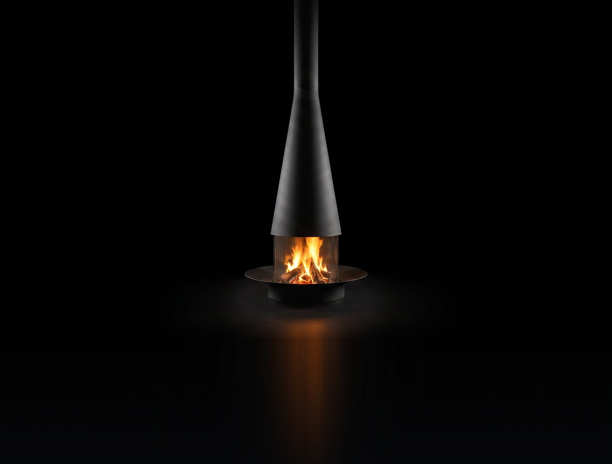 The Filiofocus Central 1600 wood fireplace burning in the black studio void, long trumpet cone over the glass fire ring