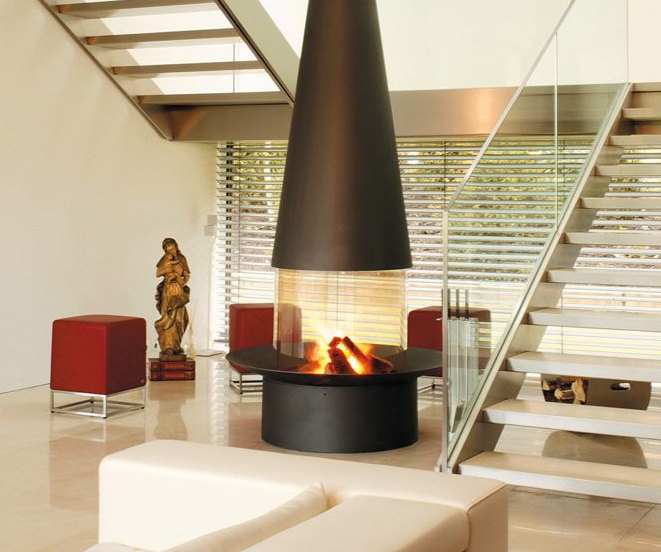 Filiofocus central fireplace with its round glass screen at the foot of a floating staircase