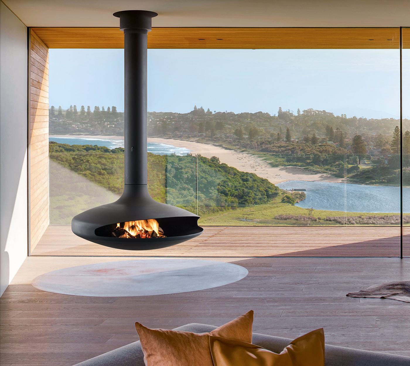 Black Gyrofocus suspended fireplace burning before a floor-to-ceiling window above a beach headland
