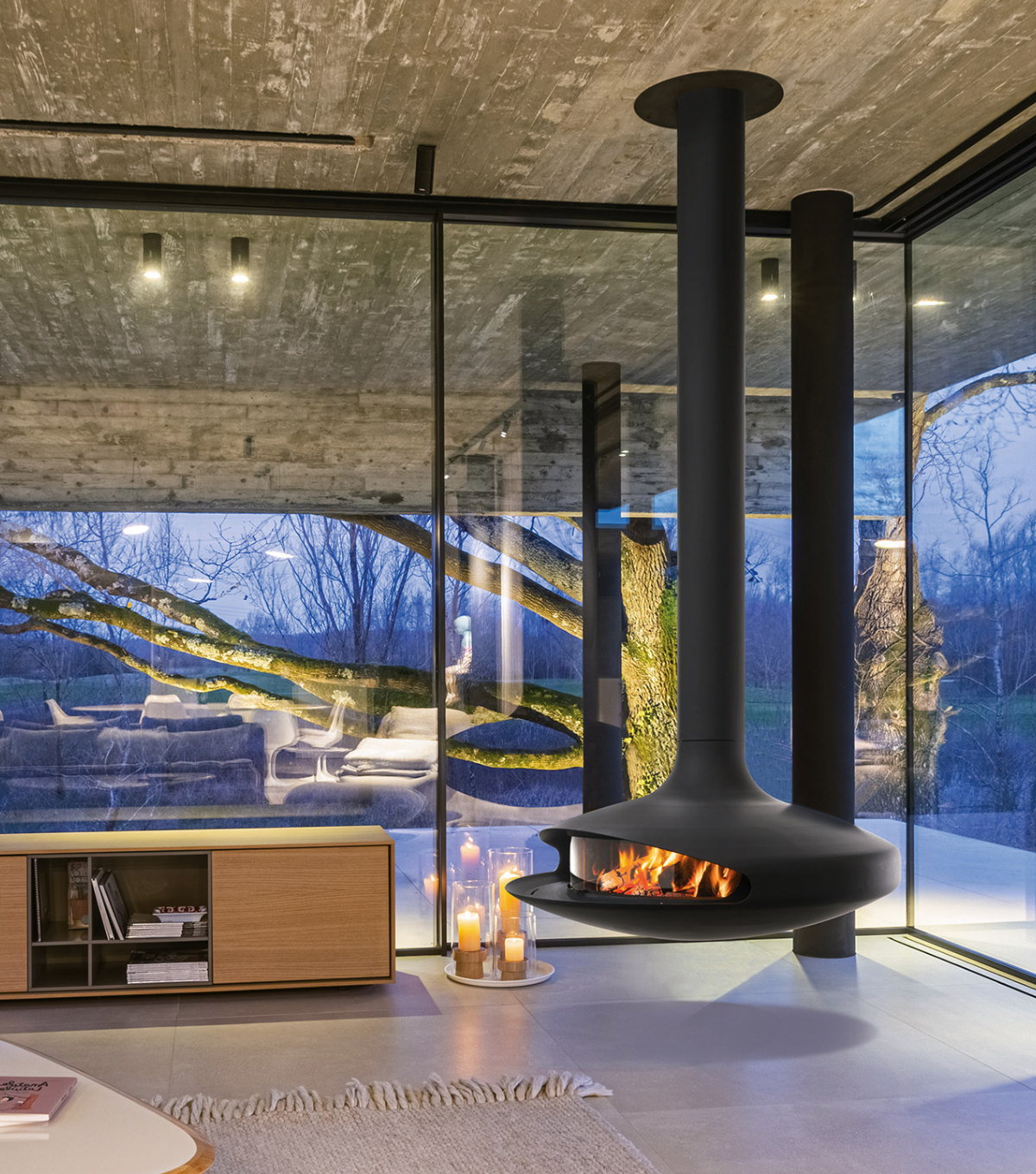 Gyrofocus burning at dusk in a glass-walled living room lit by candles