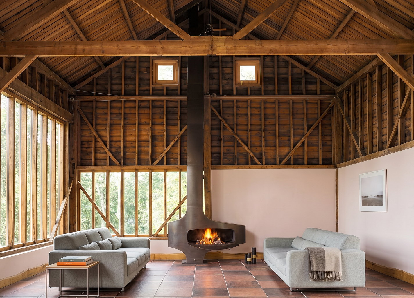 Heterofocus burning in a converted barn with an exposed timber frame and a glazed wall behind