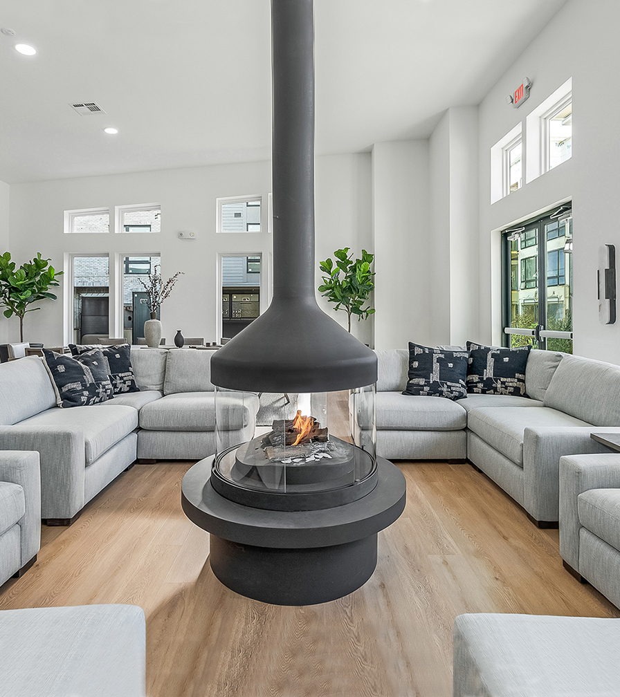 Meijifocus Gas lit behind its glass ring beside a pale sectional sofa