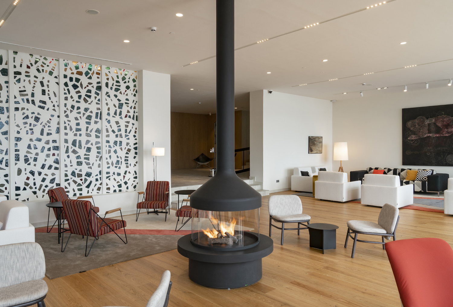 Meijifocus gas at the centre of a bright lounge with a terrazzo screen and red chairs