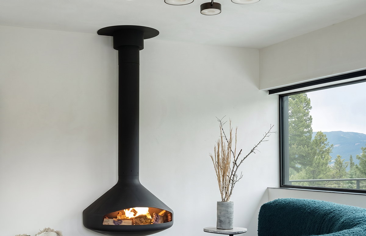 Paxfocus Gas burning against a white wall above teal boucle sofas