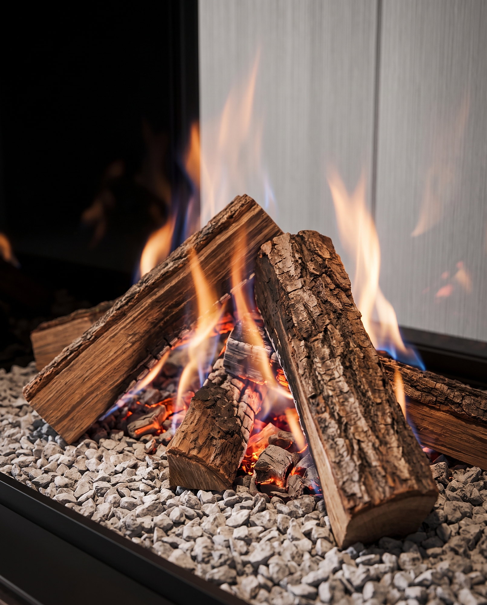 The U33 Tall&rsquo;s rough-bark split logs and embers over the pale stone bed, up close