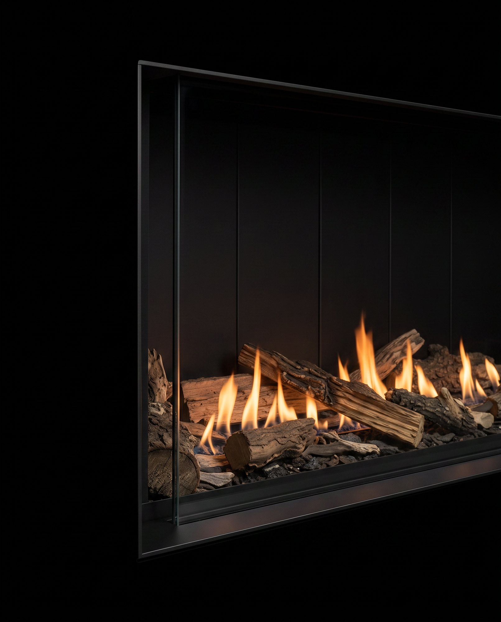 The U50 Linear’s frameless glass edge up close, split logs and flame behind the single sheet