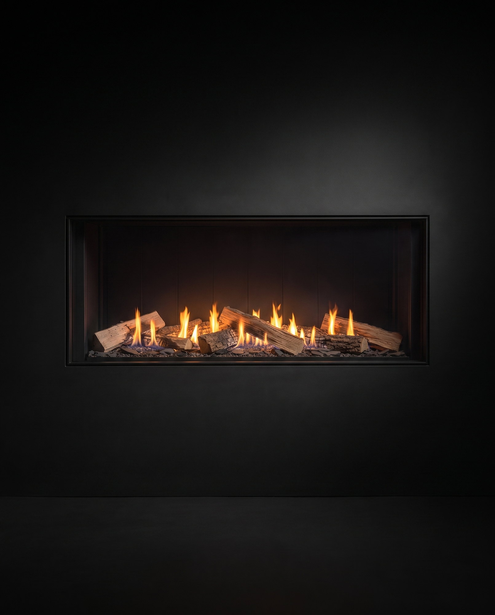 The U70 Tall Linear burning low in the evening &mdash; amber ember bed end to end under the shadowed liner