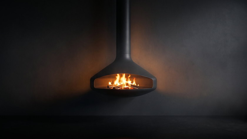 The Paxfocus — wall-mounted wood fireplace — burning against the charcoal wall