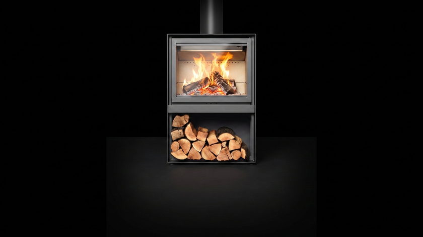 The Stûv 16 H — wood stove — burning in the black studio void