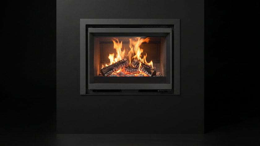 The Stûv 6-in — compact wood insert — burning in the black studio void