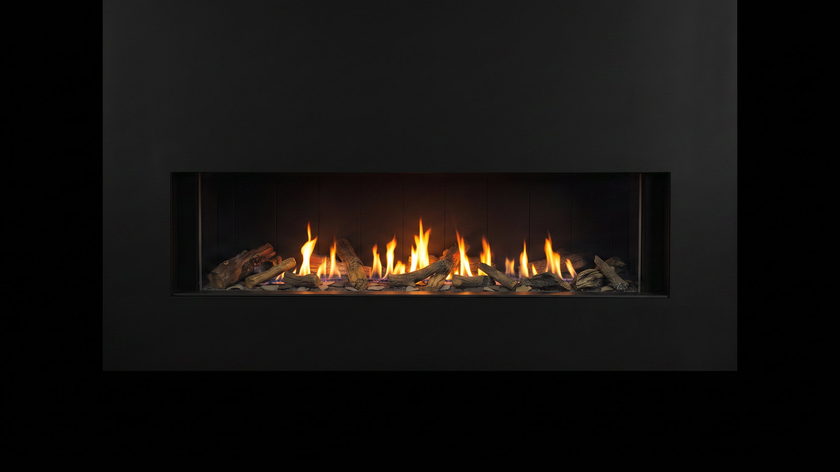 The Urbana U70 Linear — gas fireplace — burning in the black studio void