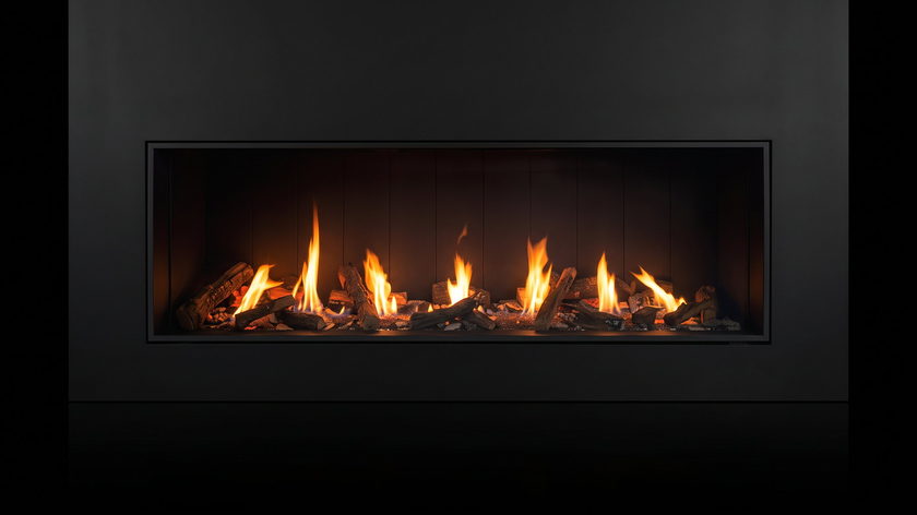 The Urbana U75 Tall Linear — gas fireplace — burning in the black studio void
