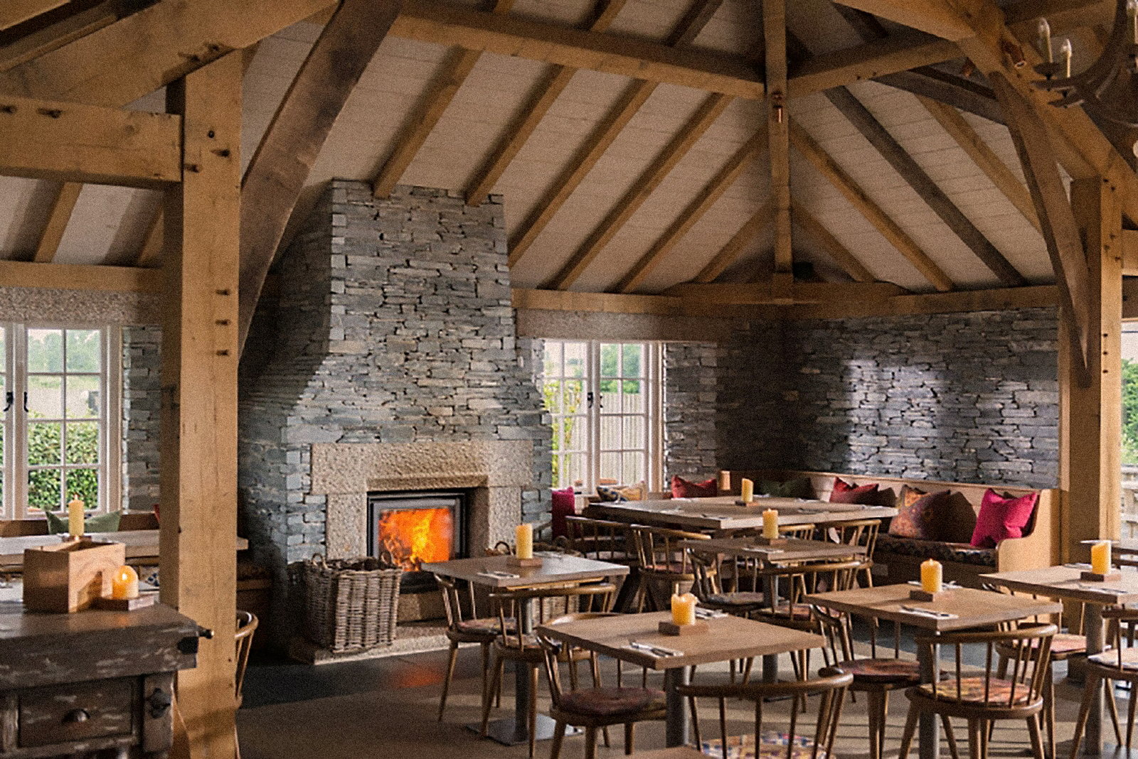 Stûv 16-in warming a timber-framed hall under a slate stone chimney