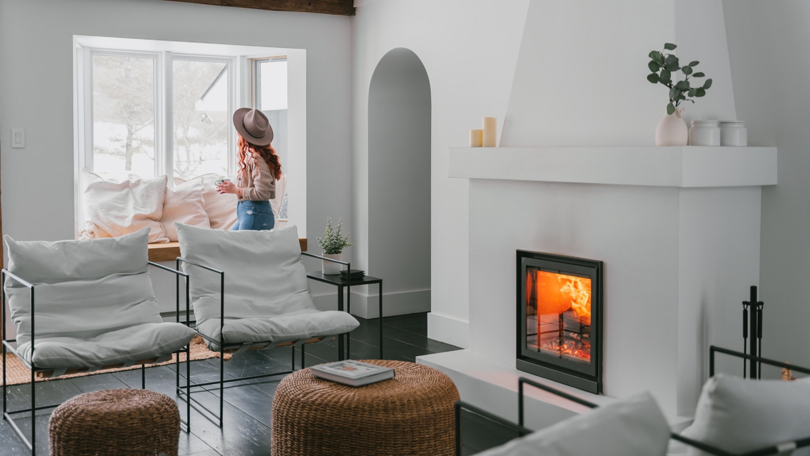 Stûv 16-Z alight in a white plaster chimney between arches and a window seat