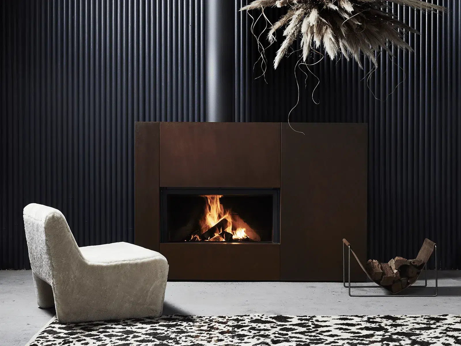 The Stûv 21-clad in dark bronze against a black fluted wall