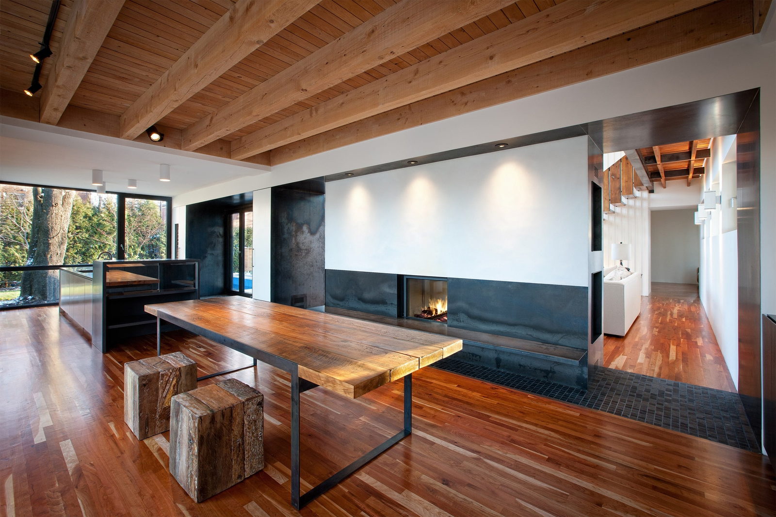 Stûv 21-85 double-sided fireplace dividing a timber-ceilinged room