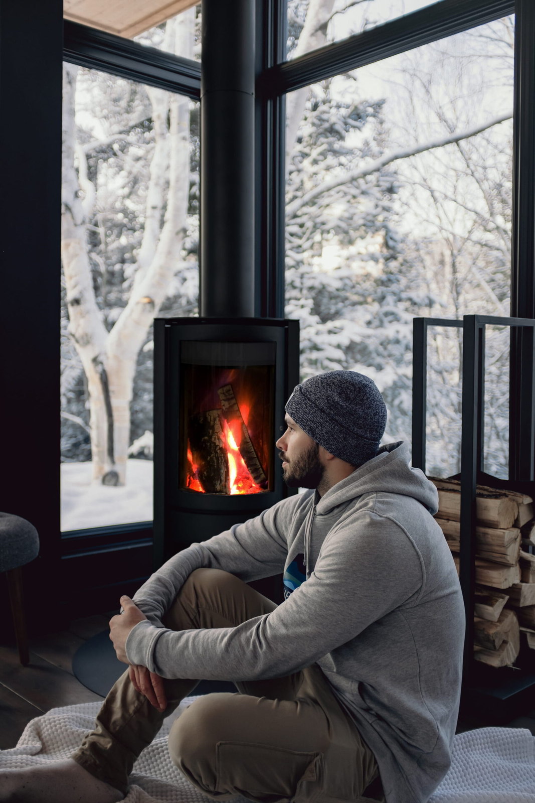The Stûv 30-Compact ONE alight while snow settles on the birches outside