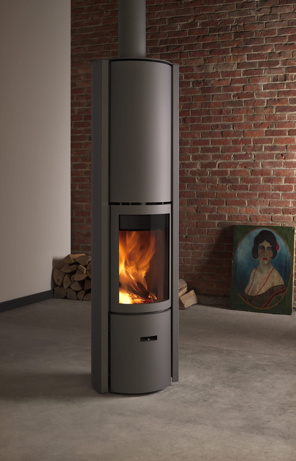 The tall Stûv 30-Compact H blazing against a red brick wall