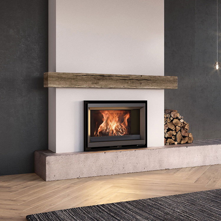 The Stûv 6-in alight over a cast concrete bench, logs stacked alongside