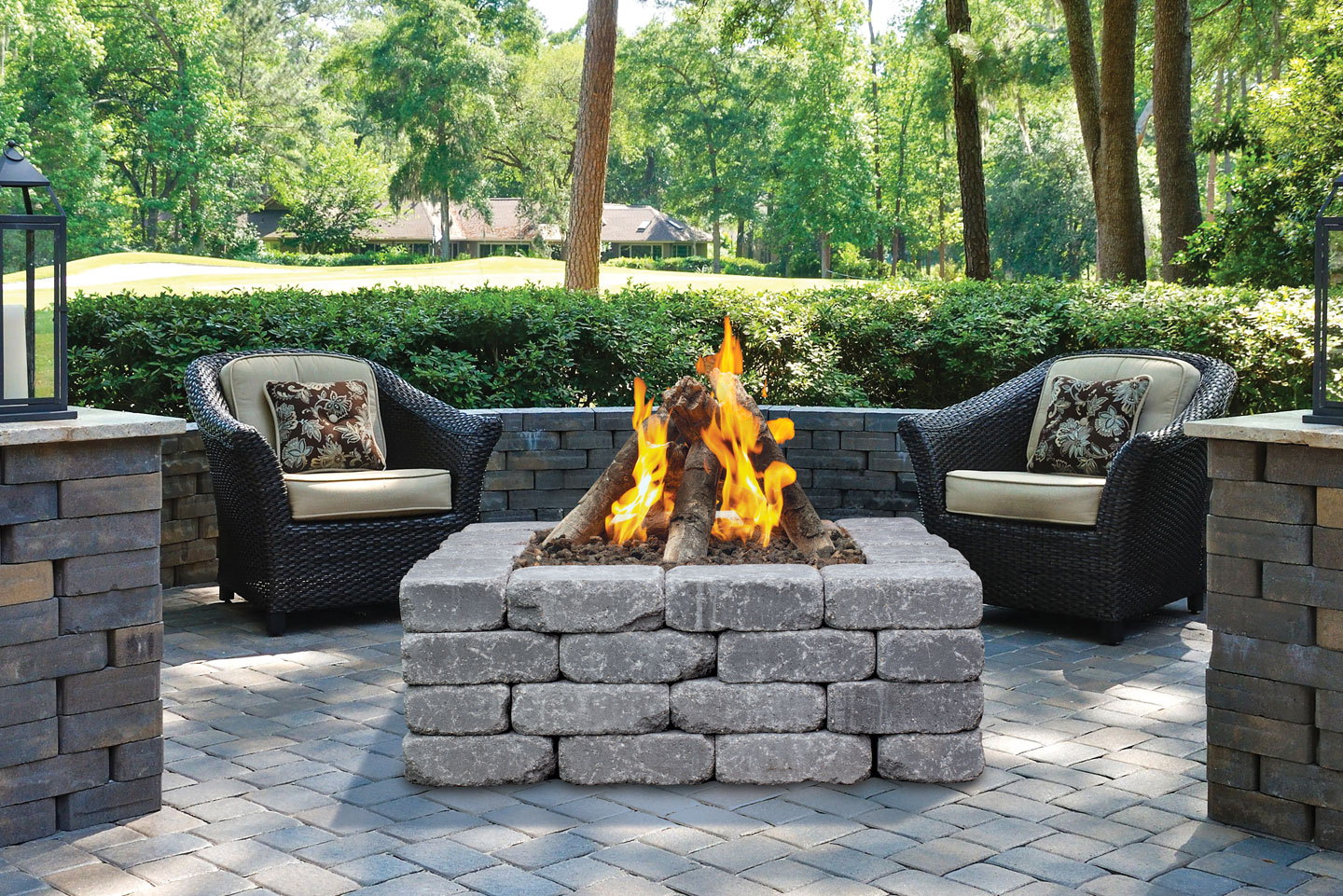 Halo brick gas fire pit between wicker chairs in a garden lounge