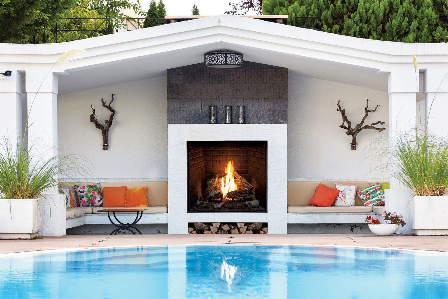 Urbana U44 Outdoor gas fireplace in a white pool cabana with orange cushions