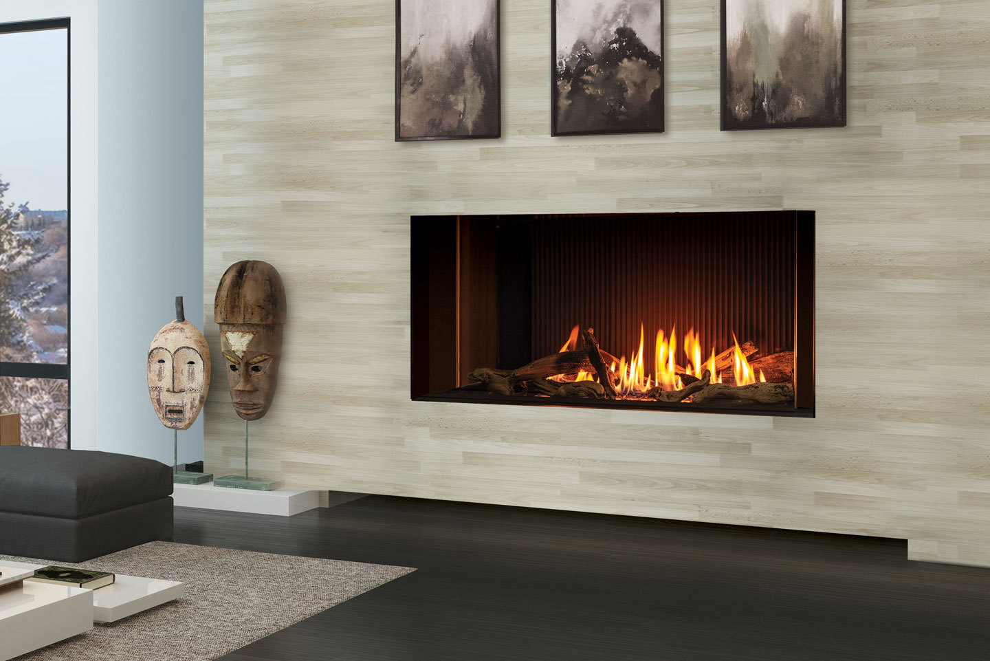 Urbana U50 Tall Linear gas fireplace in a pale stone wall between carved masks